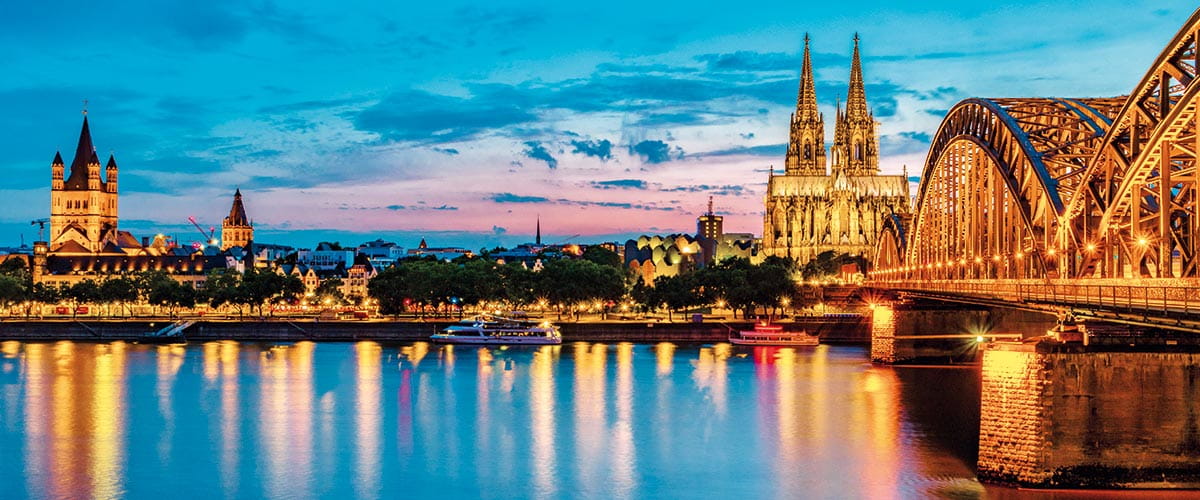 A view across the Rhine River towards the city of Cologne at sunset